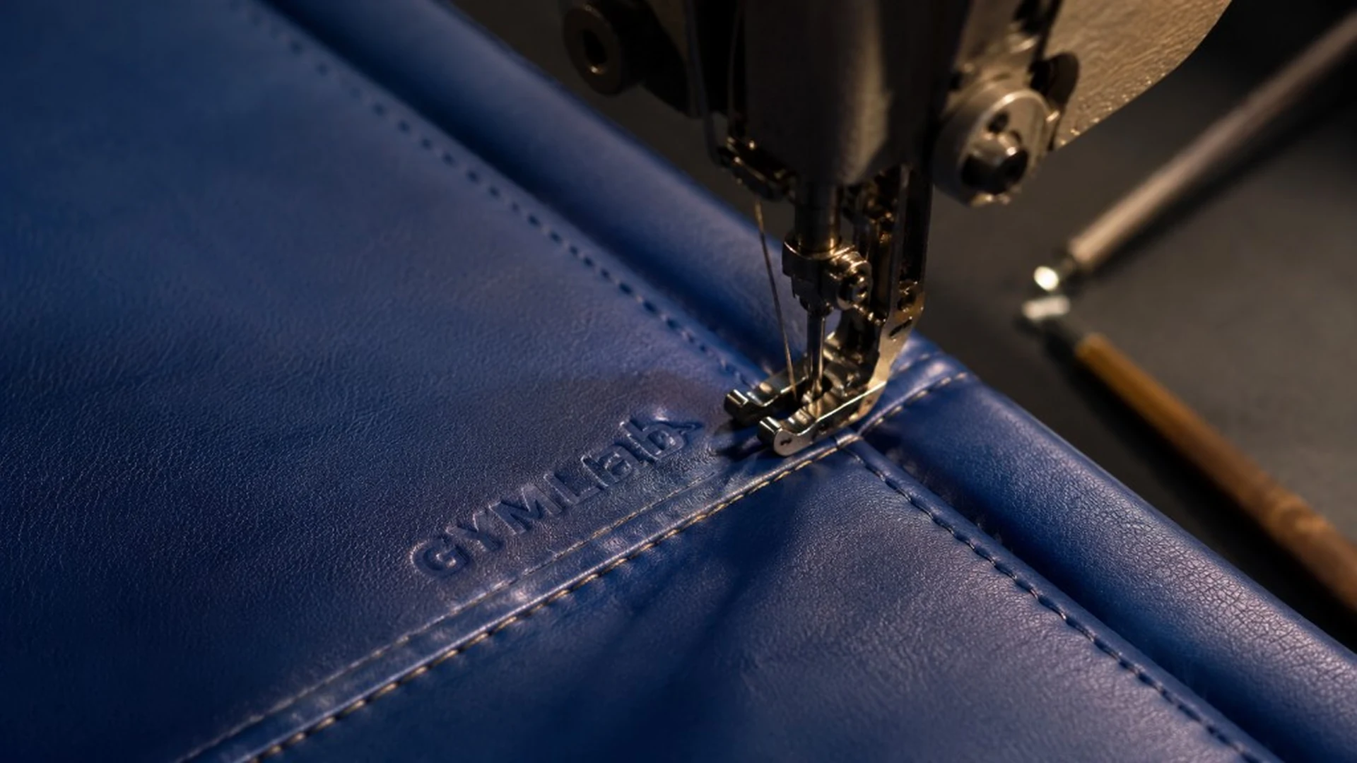 Industrial sewing machine stitching GYMLAB branded upholstery